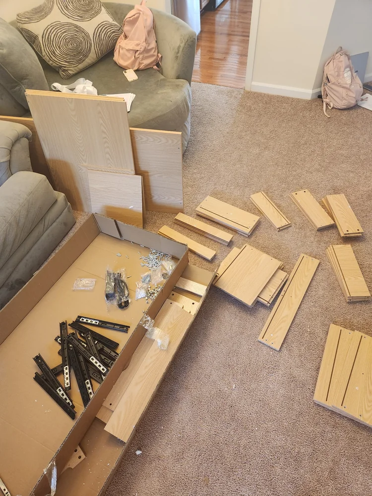 Desk panels and hardware laid out before furniture assembly